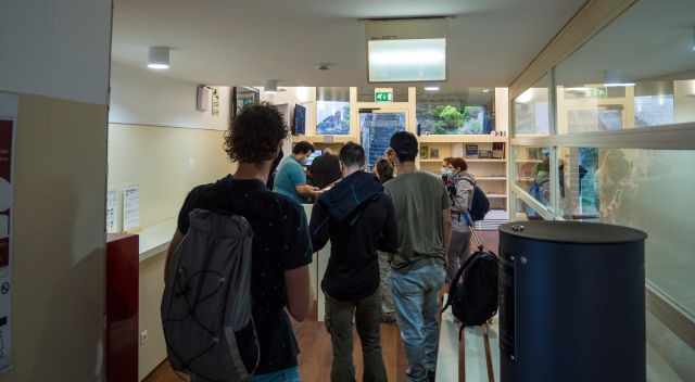 Hikers queuing in the mountain hut. 