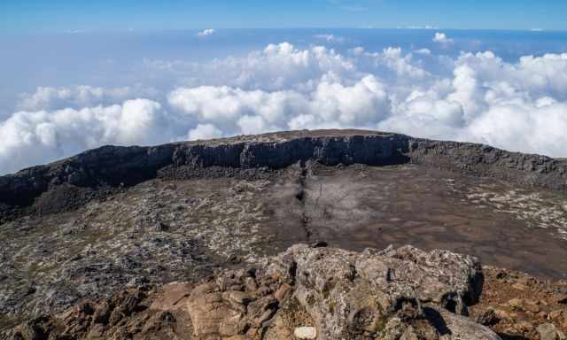 The view from the pico cone down into the crater and a blue sky in the back.