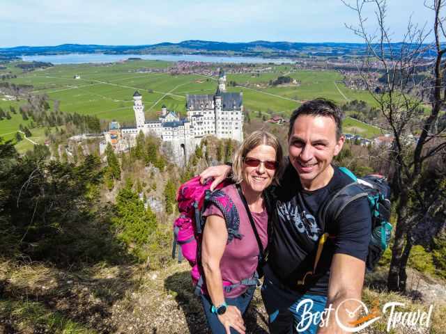 Two visitors at high elevation with Neuschwanstein Castle in the back.