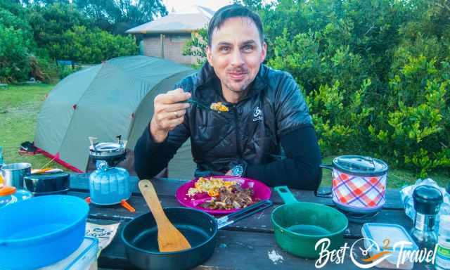 A camper enjoying his meal in front of his tent on Maria Island