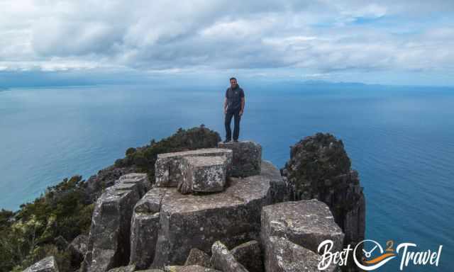 Bishop and Clerk - a hiker on the summit with the Tasman Sea in the back