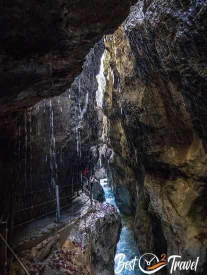 Tropfendes Wasser und orangefarbene Blätter im Herbst an den Wänden der Schlucht