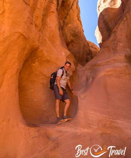 A climber at Peek-A-Boo entrance in glowing orange light