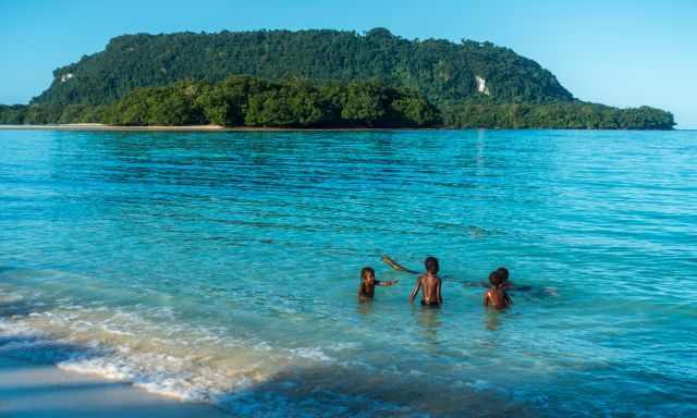 Four young kids playing in the emerald sea