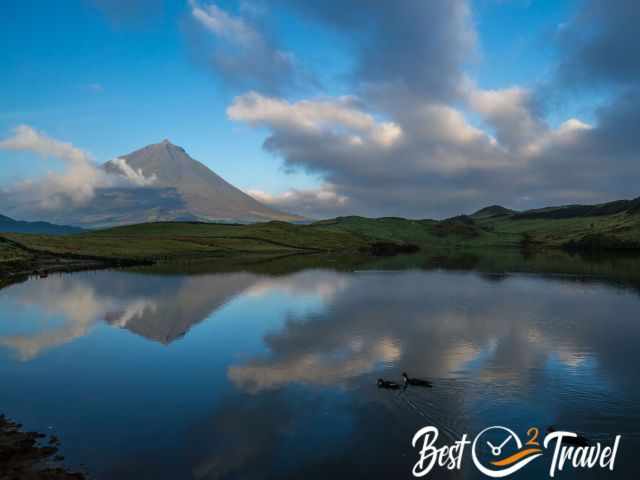 Reflection of Pico Mountain on the still water of Lagoa do Capitão on a calm, windless day.