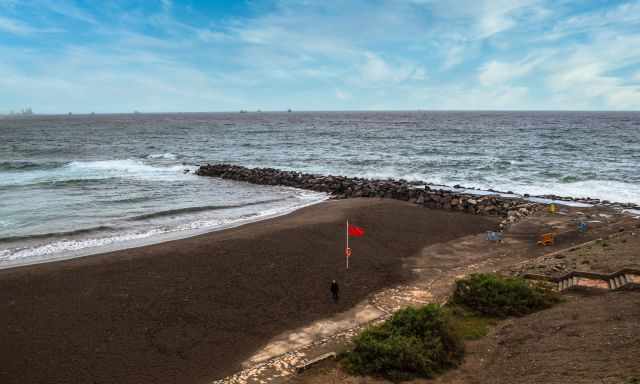 Playa de la Laja with a red flag on a very windy day.