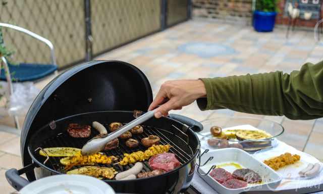 Weber charcoal grill with meat and veggies