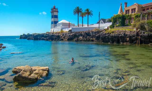 A swimmer at Santa Marta beach and cove with the lighthouse in the back