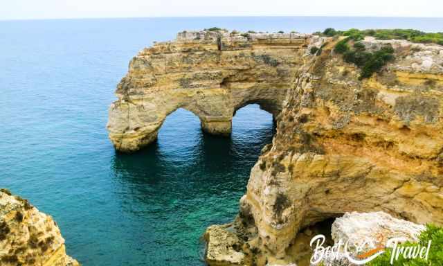 View from the cliffs to Praia Marinha and two rock arches.