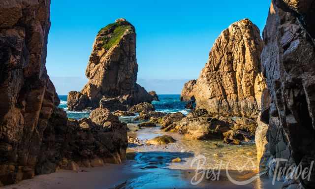 A gap between two rocks leads into the sea