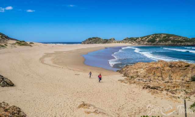 Two visitors are walking at the Island beach