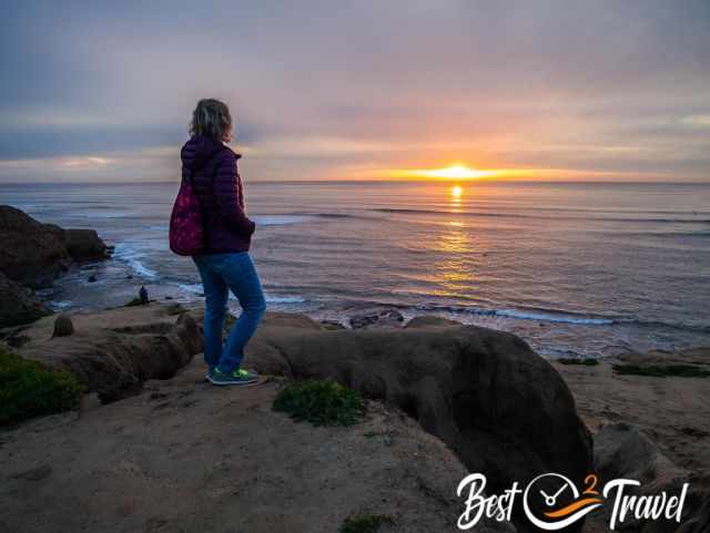 A woman at the cliffs watching the sunset