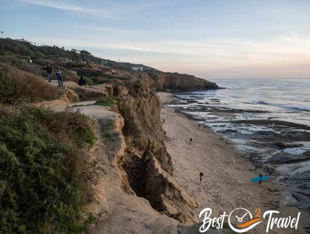The steep and fragile cliffs and Sunset Beach with visitors.