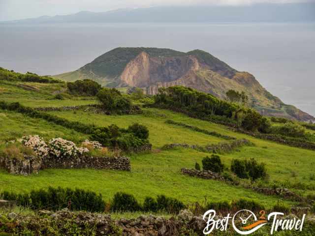 The green fields, hydrangea and a crater at the sea