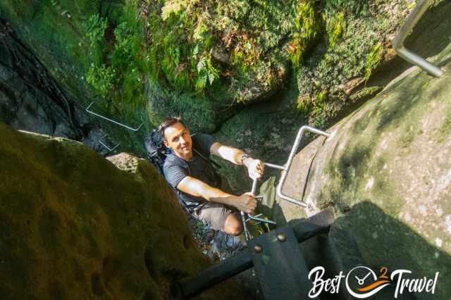 A man climbing up the wall with the help of iron fixings