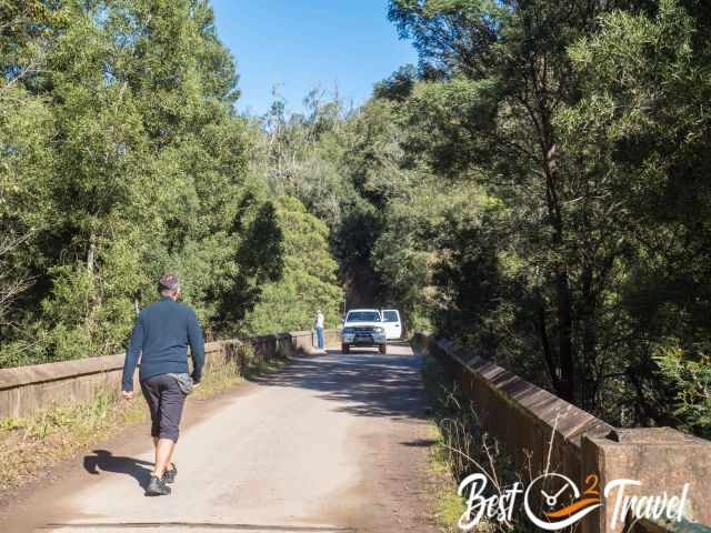 A 4 WD on a bridge and dirt road.