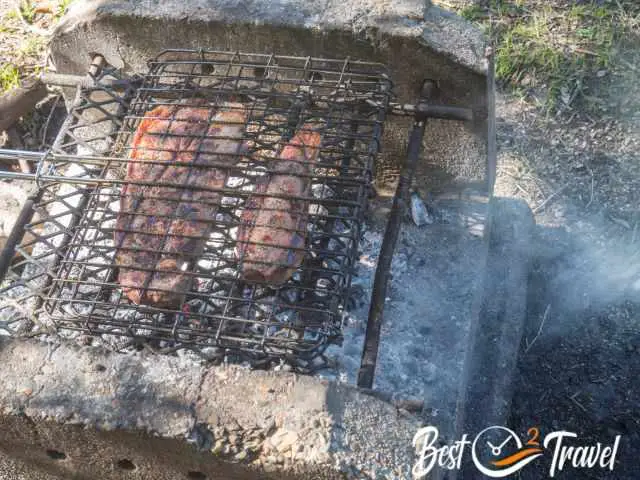 Basic braai station with grids and meat on it.