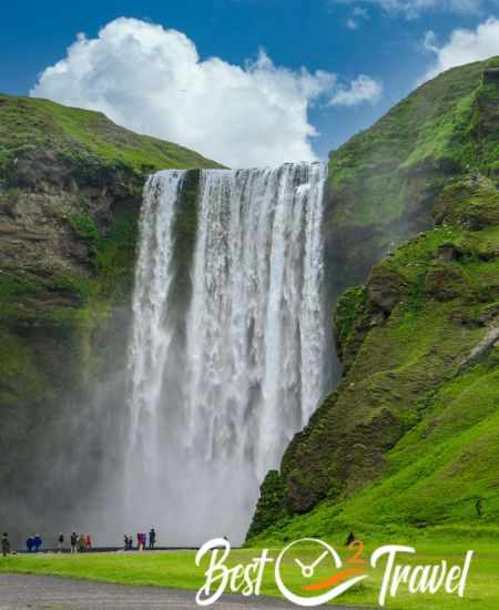 Skogafoss in the late afternoon with visitors at the bottom