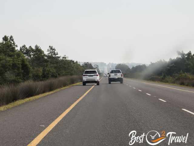 The slower car drove on the shoulder.