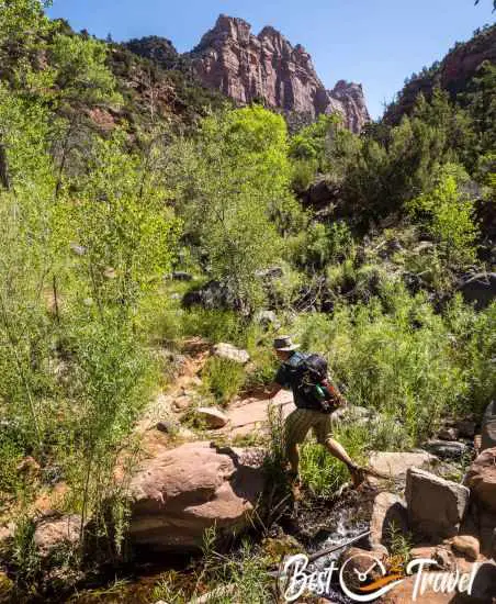 A hiker jumping above the creek
