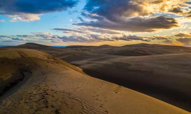 Red and pink sunset clouds and the dunes of Maspalomas