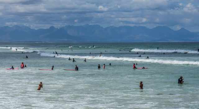 The sea at Cape Town full of people and surfers.