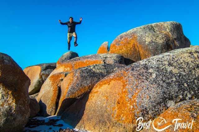 A man jumping between the massive orange Cobler Rocks
