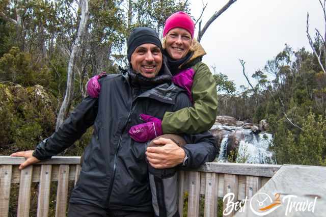A couple in warm winter clothes at a wild river