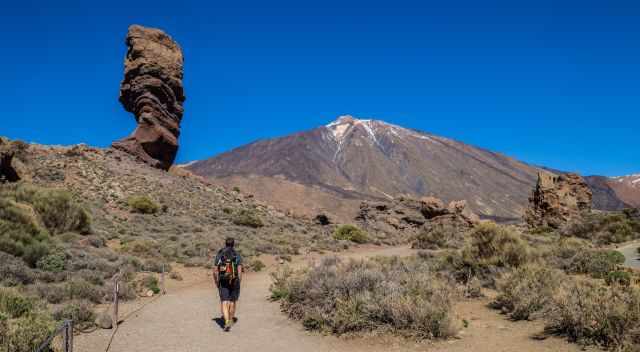 Hiker along Roque Cinchado and Teide in the back