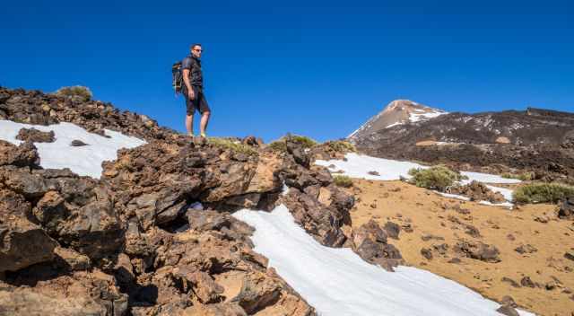 Hiker on the trail to the top of Pico Viejo with Teide in the back