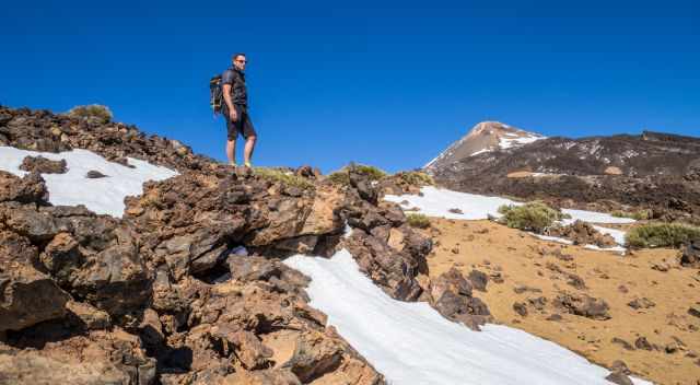 Hiker on the trail to the top of Pico Viejo with Teide in the back