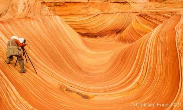 A professional photographer with tripod in the Wave.