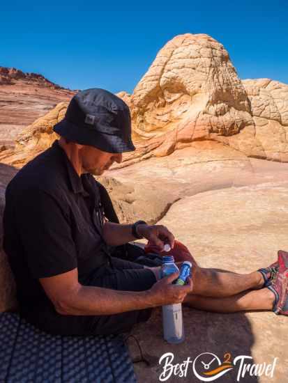 Sitting in the shade and preparing water with electrolytes.