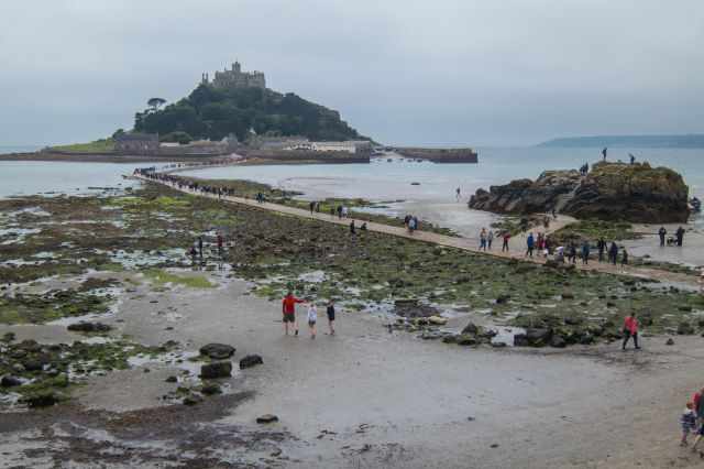 The Mount and causeway with visitors on a cloudy day.