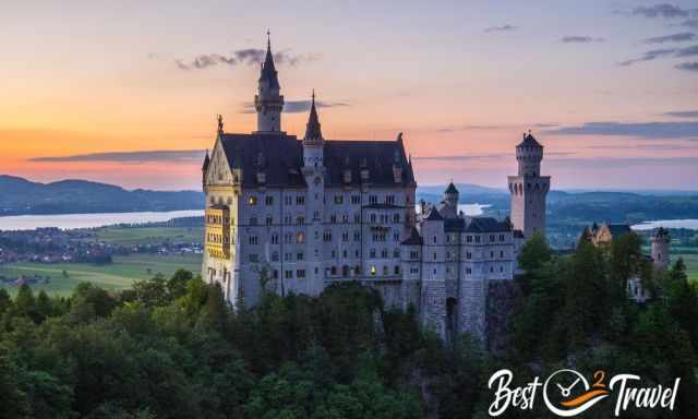 View to Neuschwanstein at sunset with switched on lights inside the castle
