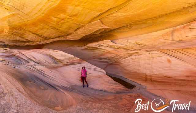 A woman on orange and white sandstone looking like paper.