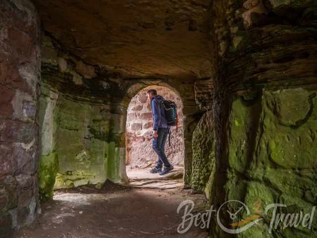 Moss covered ruin and a hiker at the entrance