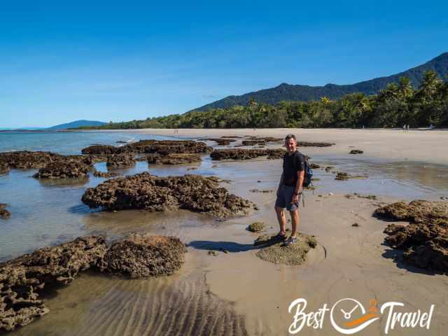 A visitor at a long stretching beach in the Daintree.