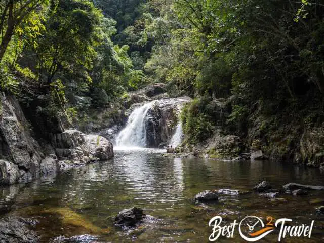 A couple sitting in front of a waterfall in the distance.