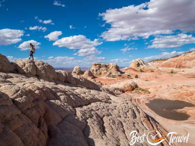 A woman on white rock formations and colourful ones in the back