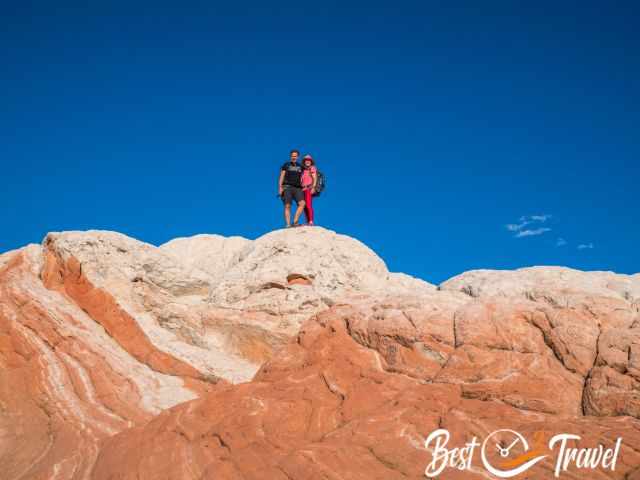 A couple on the top of a white-reddish rock formation