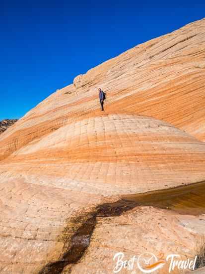 A hiker on the top of a rocky dome