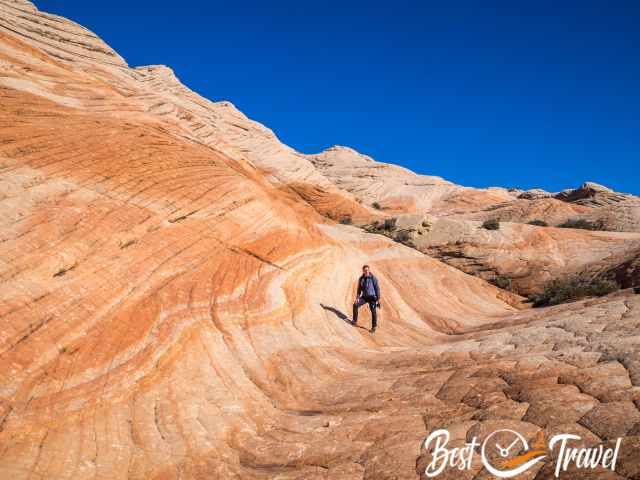 A hiker in the wave rock formation at the Candy Cliffs