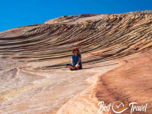 Me, sitting in front of a swirled rock formation.