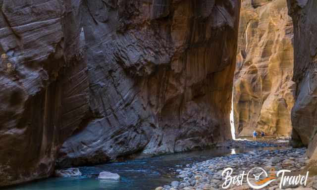 The crystal clear and blue Virgin River with two hikers in the back