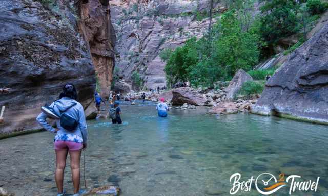 People wading through the ankle deep to waist-deep Virgin River. 