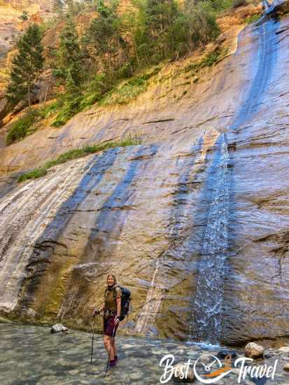 A hiker at a waterfall at the beginning of the Narrows