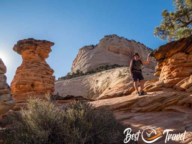 A hiker at hoodoos and a massive Mesa